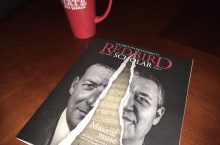 Redbird Scholar magazine on a table next to a coffee mug
