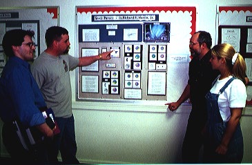 Students discussing a research poster with Dr. Martin